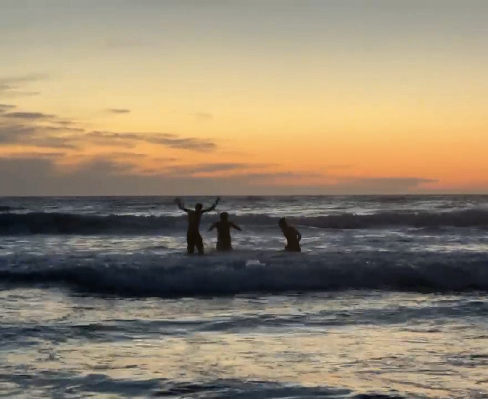 dipping in the ocean beach at sunset
